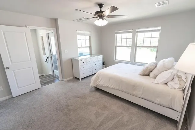 a spacious bedroom with a bed dresser and a window