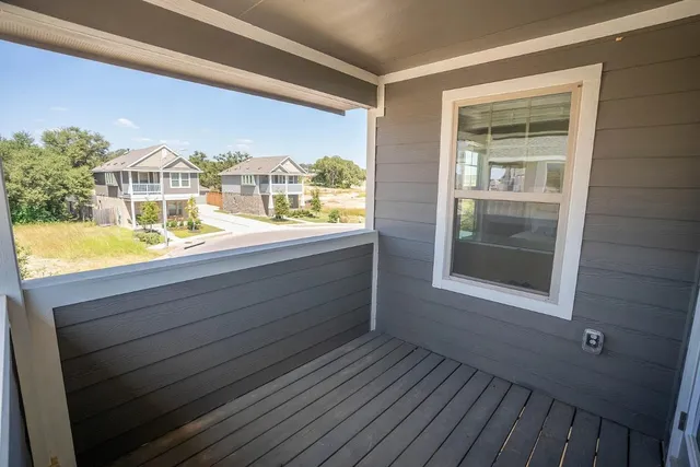 a view of a balcony with wooden floor and a yard