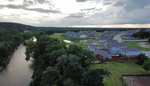 an aerial view of a city with lots of residential buildings lake and mountain view in back