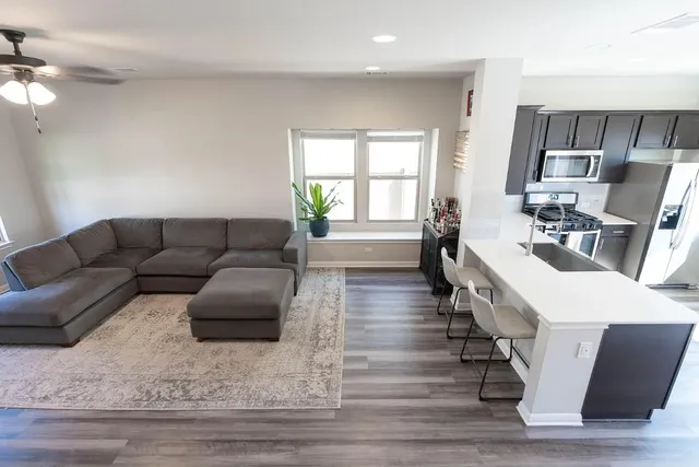 a living room with furniture a wooden floor and a sink