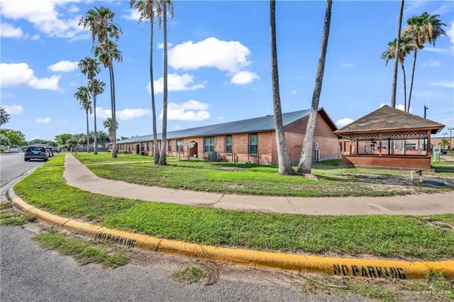 a front view of a house with a yard and lake view