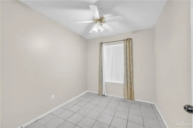 an empty room with white walls and ceiling fan