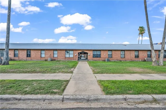 a front view of brick house with a yard