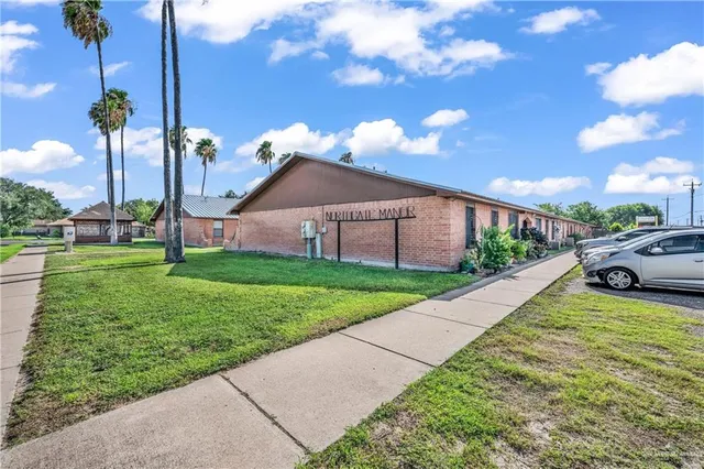 a view of a house with a big yard and a garden