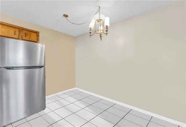 a view of a refrigerator in kitchen and empty room