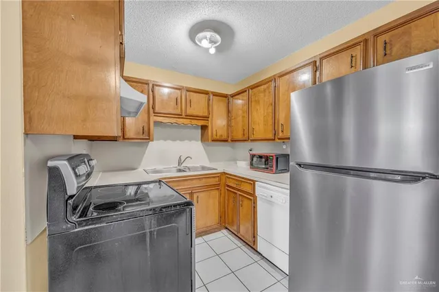 a kitchen with stainless steel appliances a refrigerator a sink and a stove