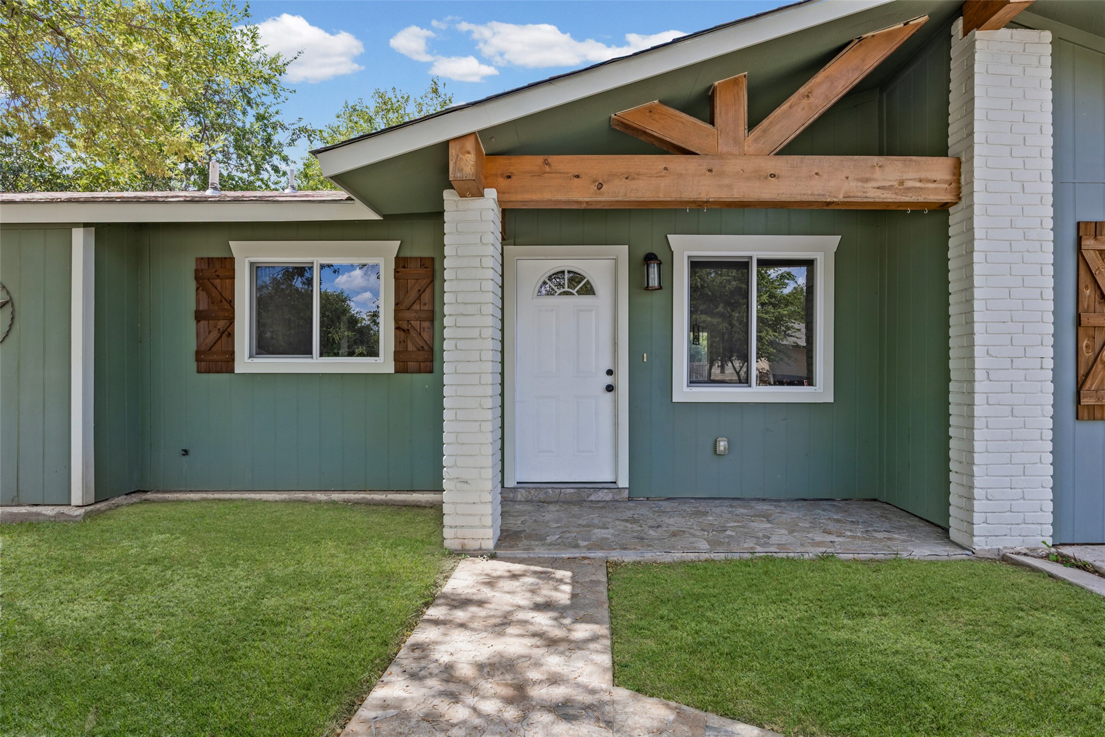 An inviting front porch with timber framing and stone flooring welcomes visitors home.