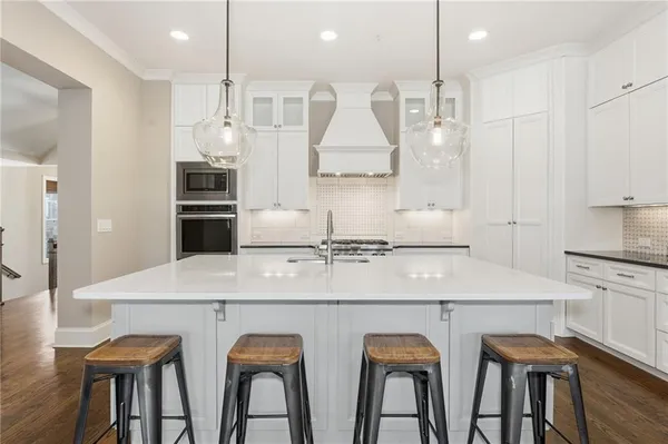 a kitchen that has a lot of cabinets in it with wooden floor