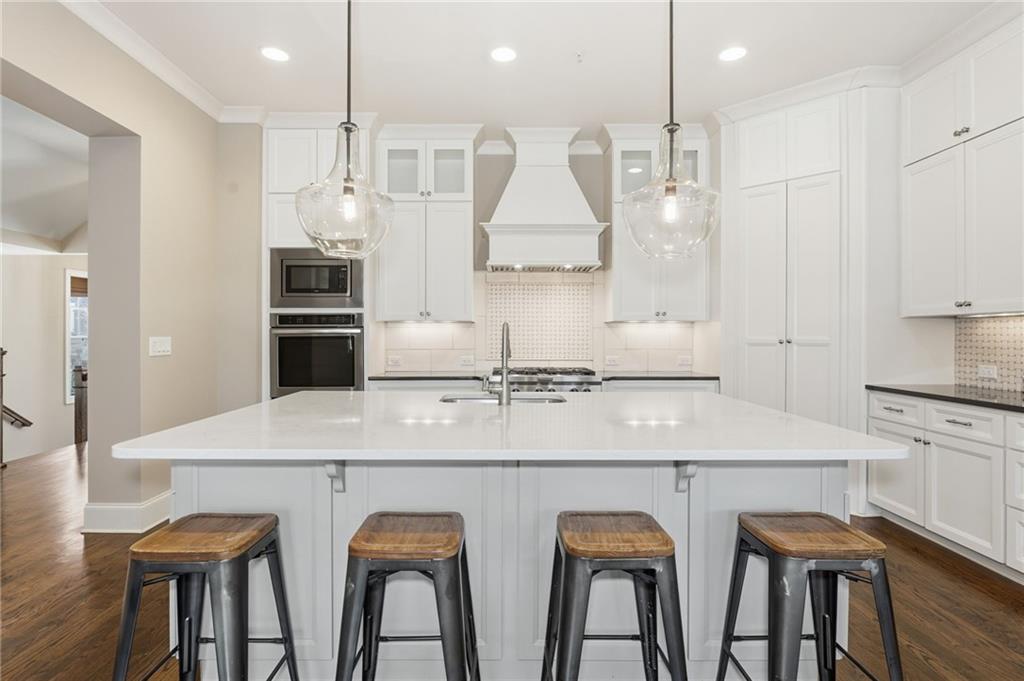 2085 Bellrick Road Northwest Atlanta, GA 30318 - Photo 11 of 78 a kitchen with stainless steel appliances granite countertop a kitchen island and chairs in it