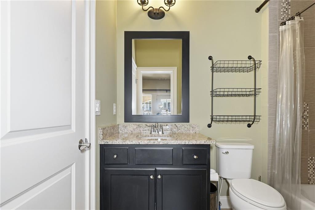 2085 Bellrick Road Northwest Atlanta, GA 30318 - Photo 48 of 78 a bathroom with a granite countertop sink toilet and mirror