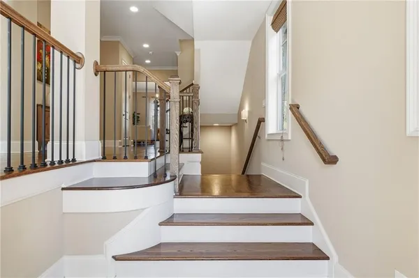 a hallway with wooden floor stairs and furniture