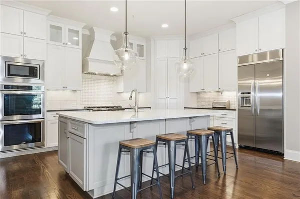 a kitchen with cabinets appliances and a wooden floor