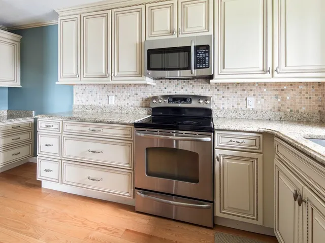 a kitchen with stainless steel appliances granite countertop a stove microwave and cabinets