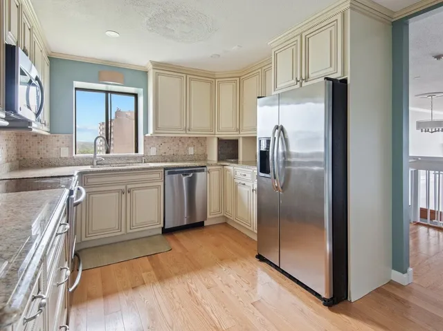 a kitchen with stainless steel appliances a refrigerator sink and cabinets
