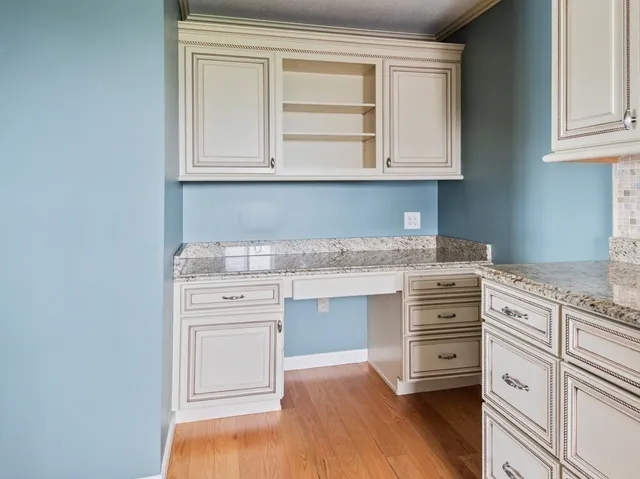 a kitchen with granite countertop white cabinets and white appliances