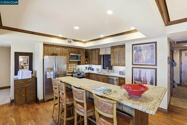 a open kitchen with stainless steel appliances granite countertop a stove refrigerator and cabinets