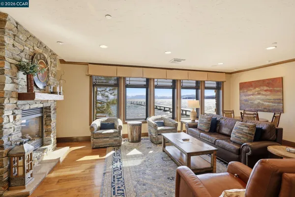 a living room with furniture large fireplace and large windows