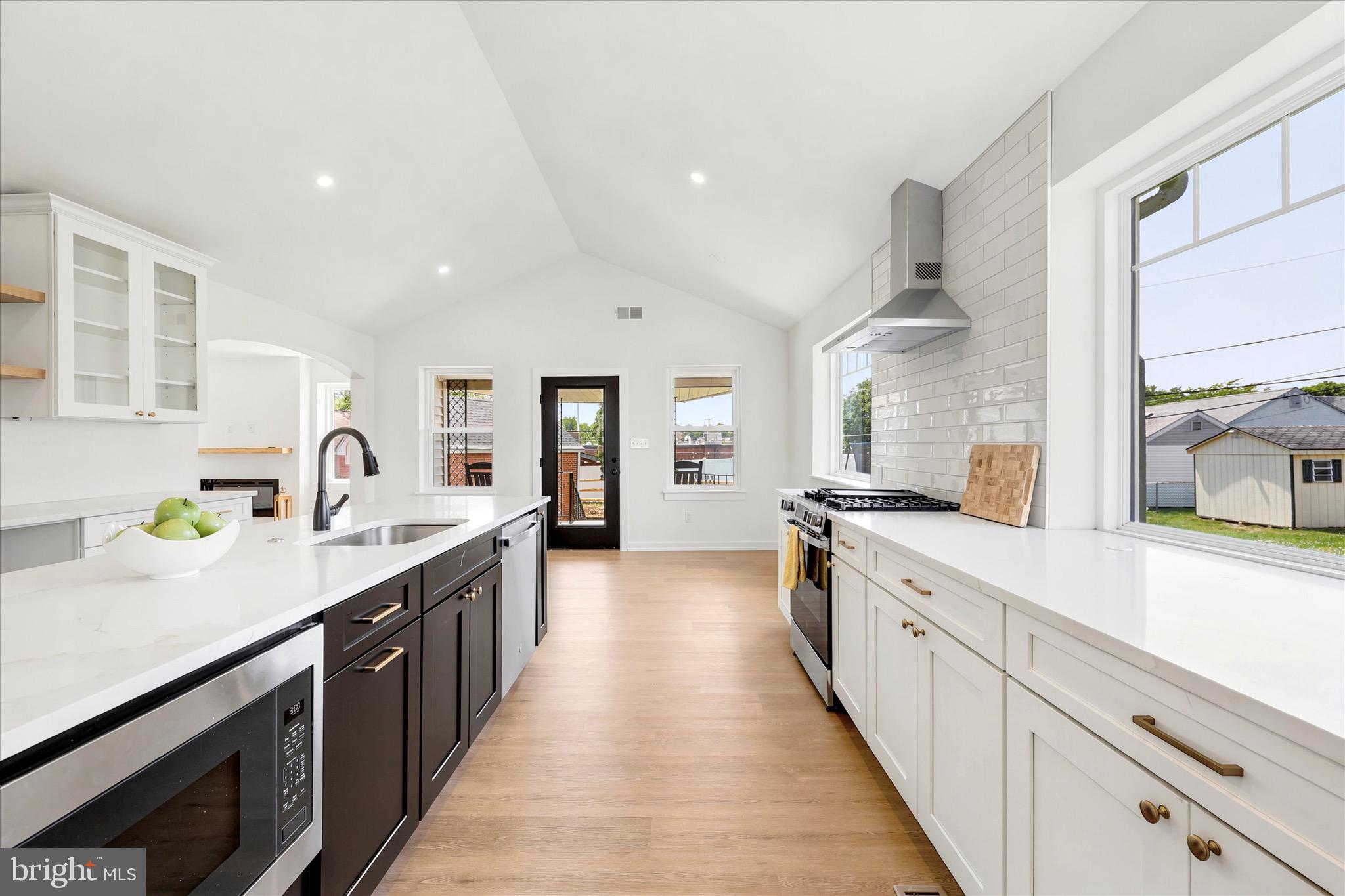 8 James Road Broomall, PA 19008 - Photo 12 of 35 a large kitchen with stainless steel appliances a sink dishwasher a stove and a refrigerator with wooden floor