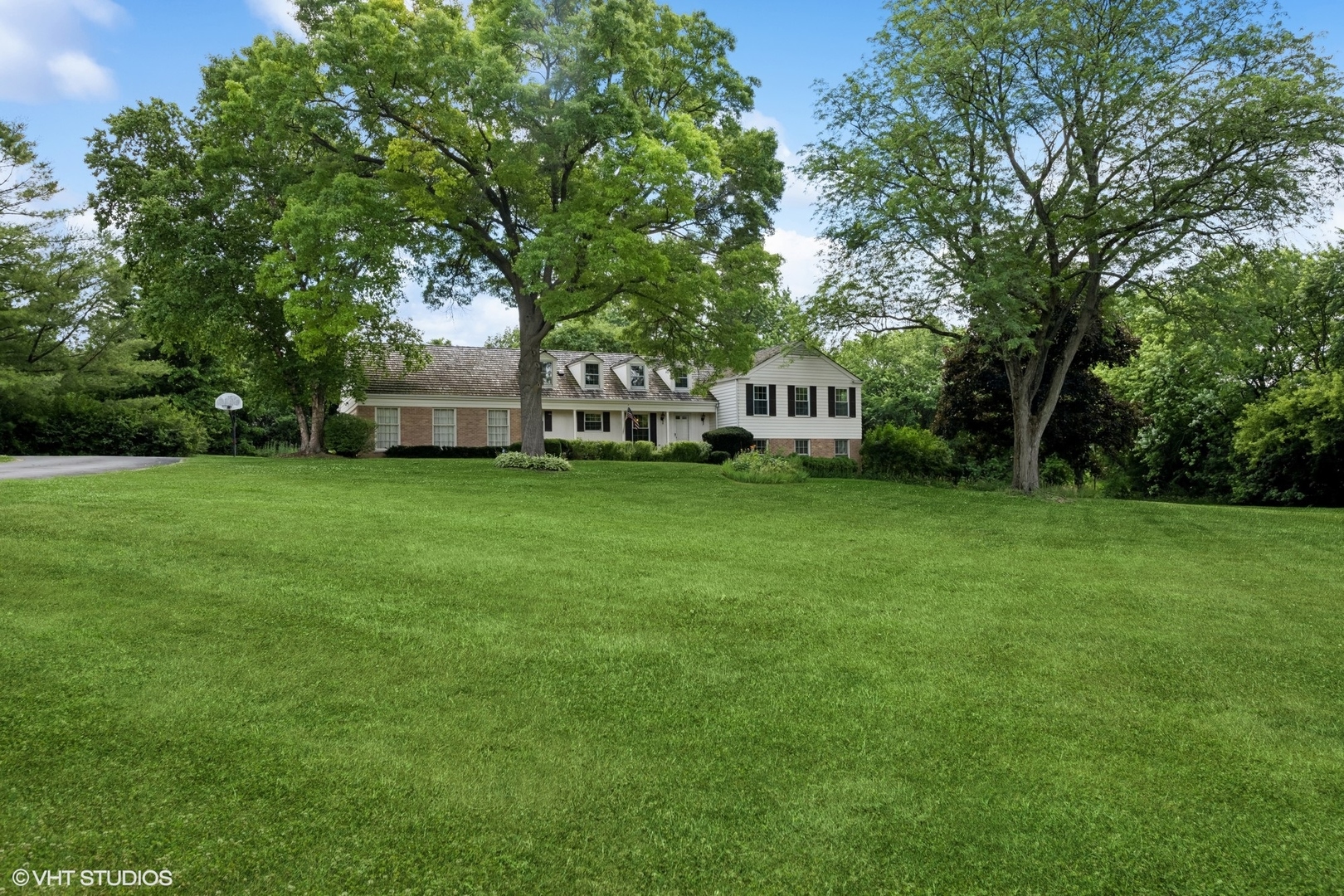 143 Firth Road Inverness, IL 60067 - Photo 2 of 38 a view of a house with a big yard and large trees