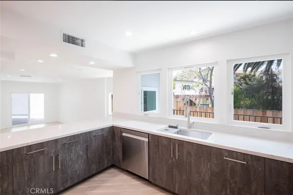 a kitchen with stainless steel appliances granite countertop a sink and a large window
