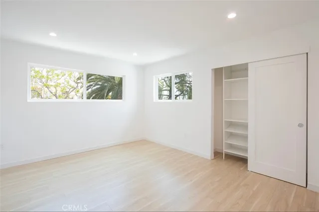 an empty room with windows and closet