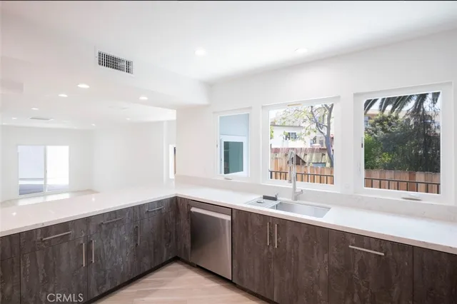 a kitchen with stainless steel appliances granite countertop a sink and a large window