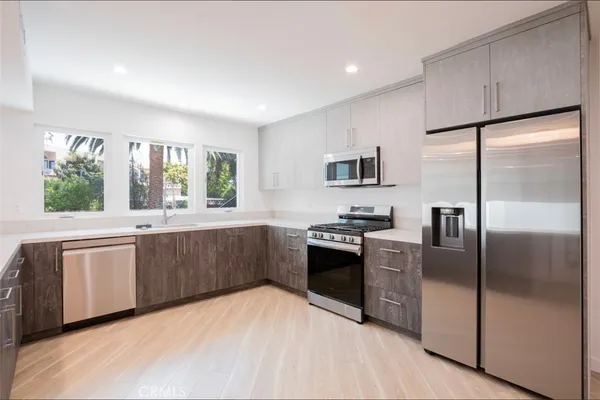 a kitchen with granite countertop a refrigerator stove top oven and sink