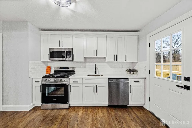 a kitchen with a stove a sink and a microwave