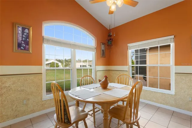 a kitchen with stainless steel appliances granite countertop a sink a oven a dining table and chairs with wooden floor