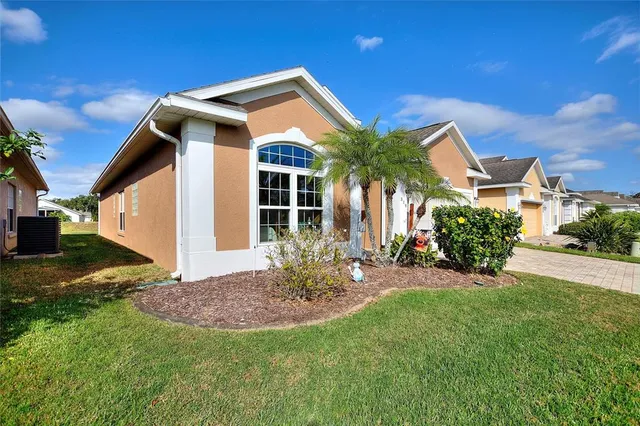 a view of a yard in front of a house with large trees