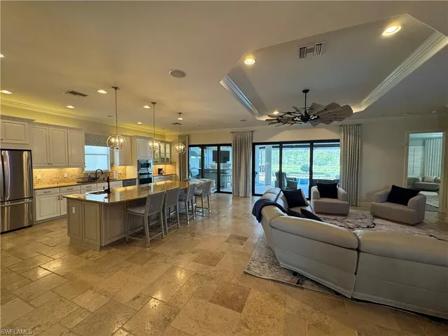 a living room with lots of furniture and kitchen view