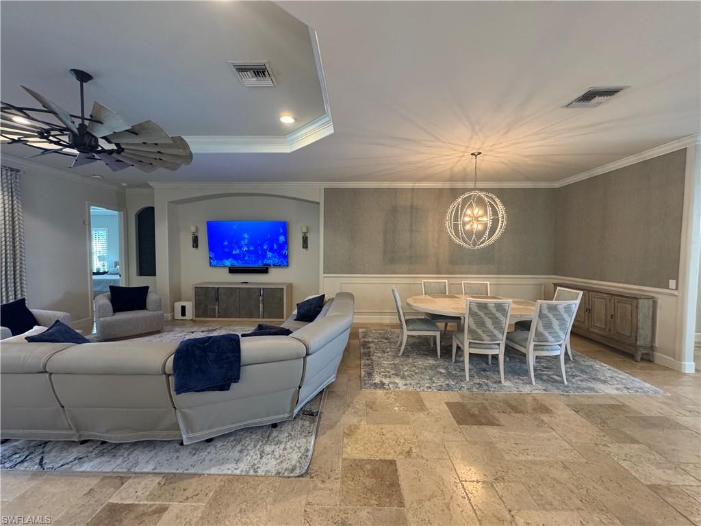9470 Galliano Terrace Naples, FL 34119 - Photo 19 of 49 a living room with furniture a chandelier and a flat screen tv