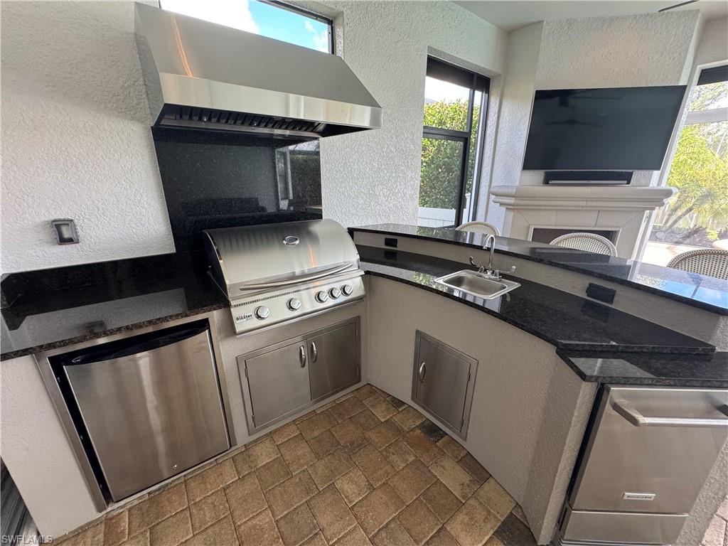 9470 Galliano Terrace Naples, FL 34119 - Photo 21 of 49 a kitchen with white cabinets and black appliances
