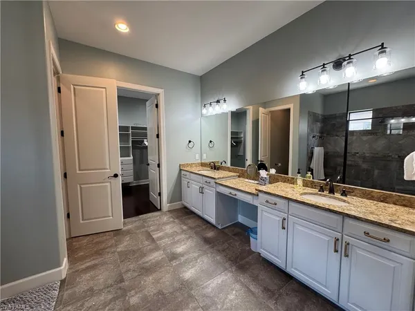 a bathroom with a glass door shower a sink and a mirror