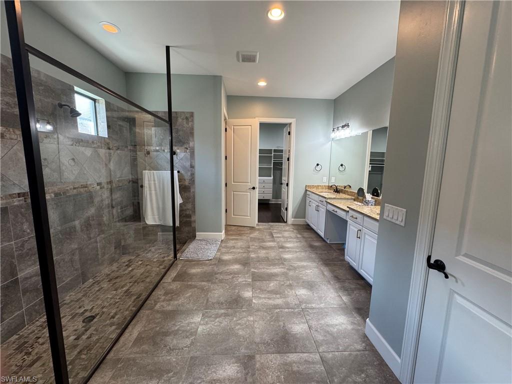 9470 Galliano Terrace Naples, FL 34119 - Photo 35 of 49 a bathroom with a glass door shower a sink and a mirror