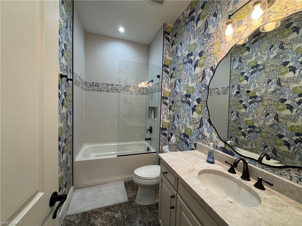 9470 Galliano Terrace Naples, FL 34119 - Photo 44 of 49 a bathroom with a granite countertop sink toilet a mirror and shower