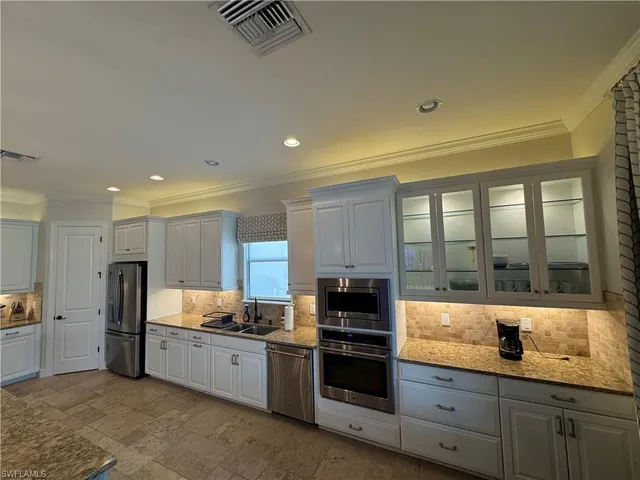 a kitchen with stainless steel appliances a refrigerator sink and cabinets