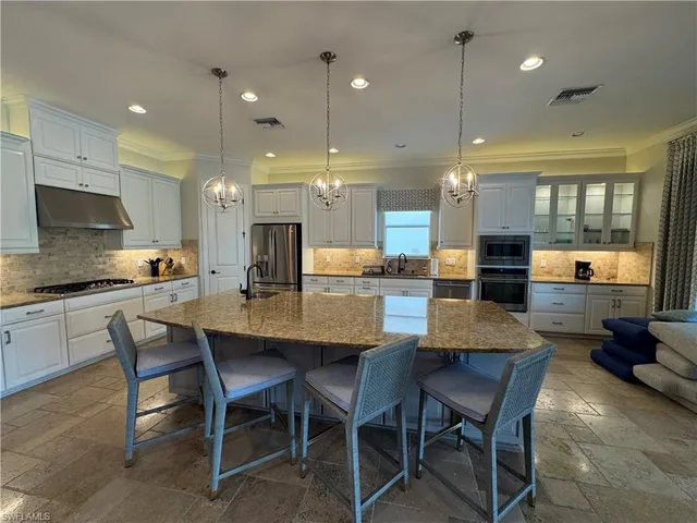 a kitchen with a dining table chairs and wooden floor