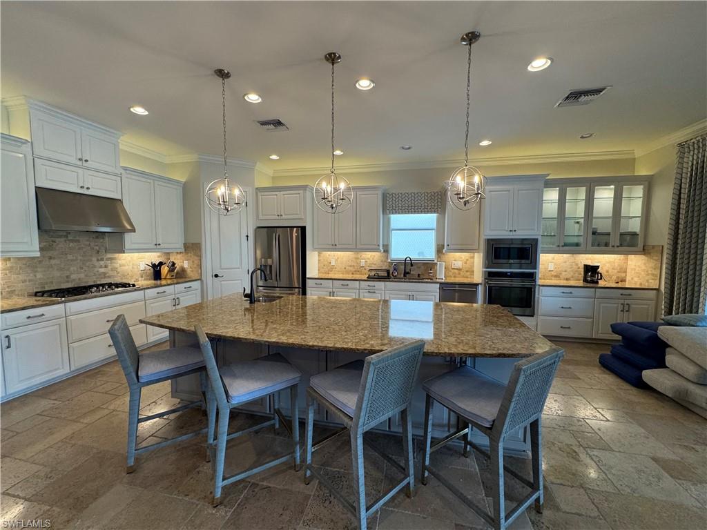 9470 Galliano Terrace Naples, FL 34119 - Photo 9 of 49 a kitchen with a dining table chairs and wooden floor