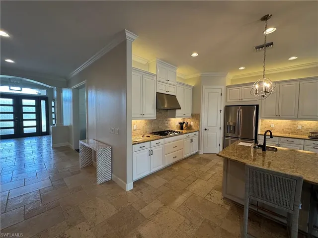 a large kitchen with a large counter top appliances and cabinets
