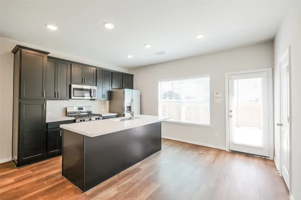 a kitchen with stainless steel appliances a refrigerator and a stove top oven