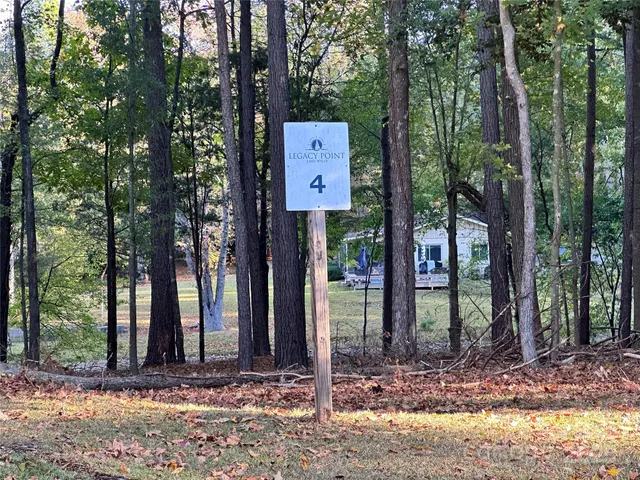 a sign that is sitting in front of a tree