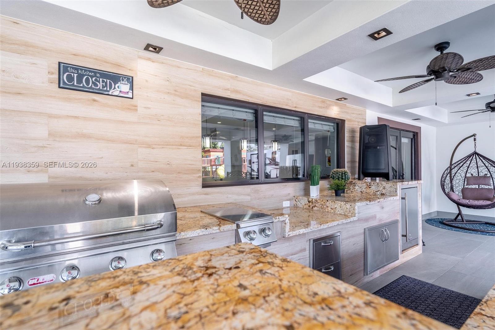 20221 Southwest 318th Street Homestead, FL 33030 - Photo 27 of 37 a room with stainless steel appliances kitchen island granite countertop a sink and cabinets