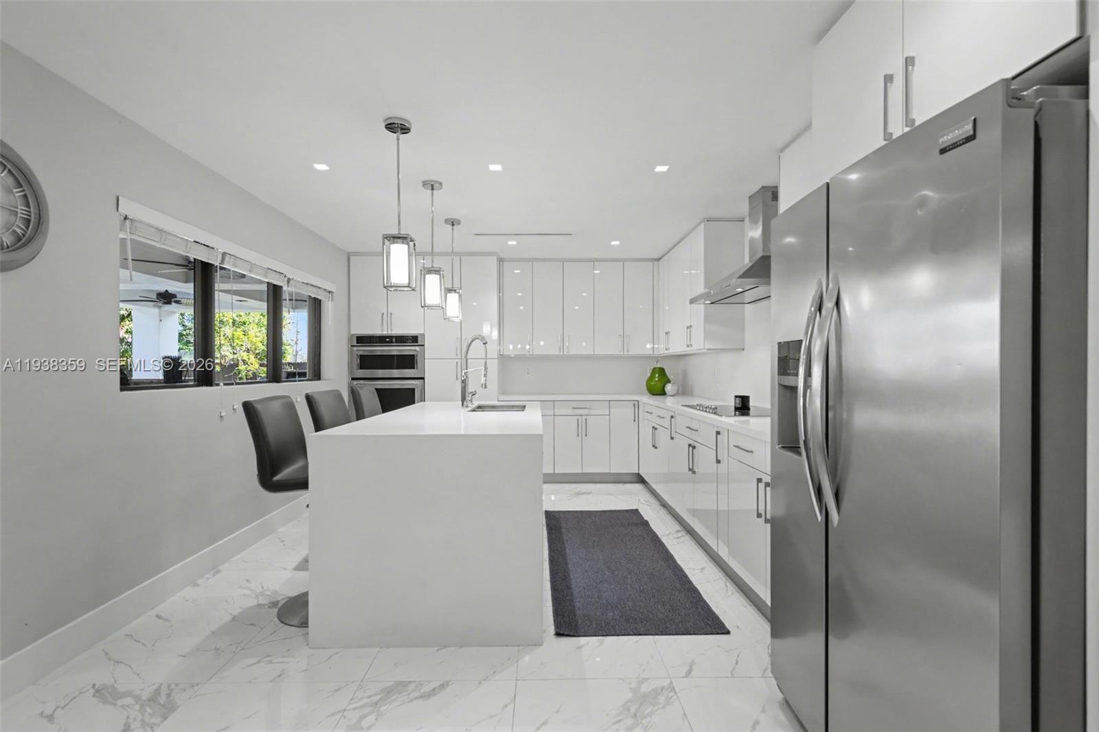 20221 Southwest 318th Street Homestead, FL 33030 - Photo 9 of 37 a large kitchen with stainless steel appliances kitchen island granite countertop a refrigerator a sink a stove and white cabinets