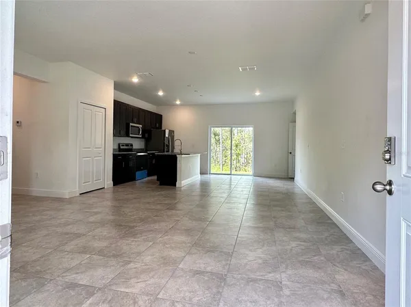 a view of a kitchen with refrigerator and windows