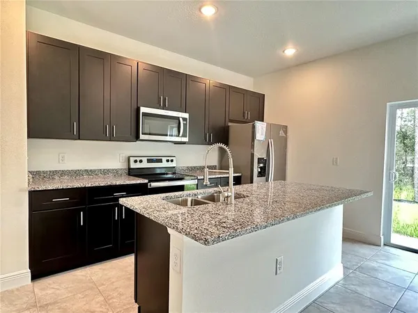 a kitchen with granite countertop a stove and a refrigerator