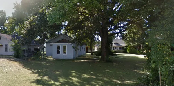 a view of a house with a tree in the yard