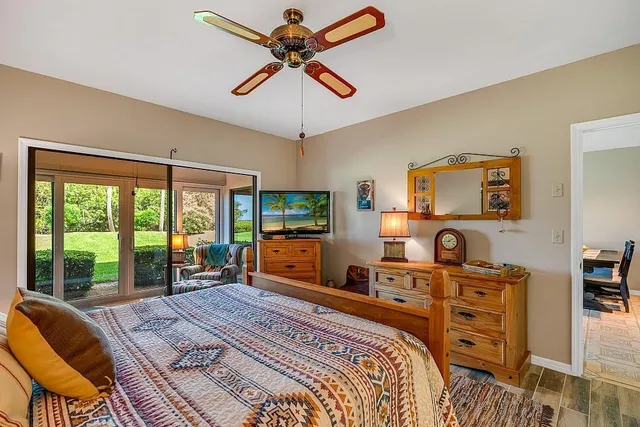 a bedroom with a bed a flat screen tv and a large window