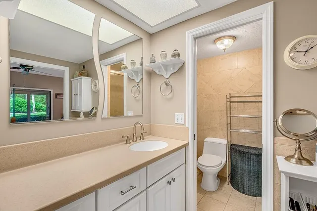 a bathroom with a toilet sink a mirror a shower and vanity