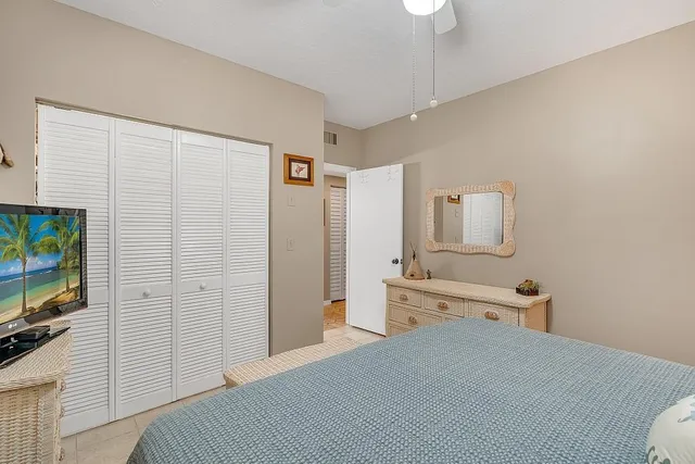 a bedroom with a bed and a flat tv screen on wall
